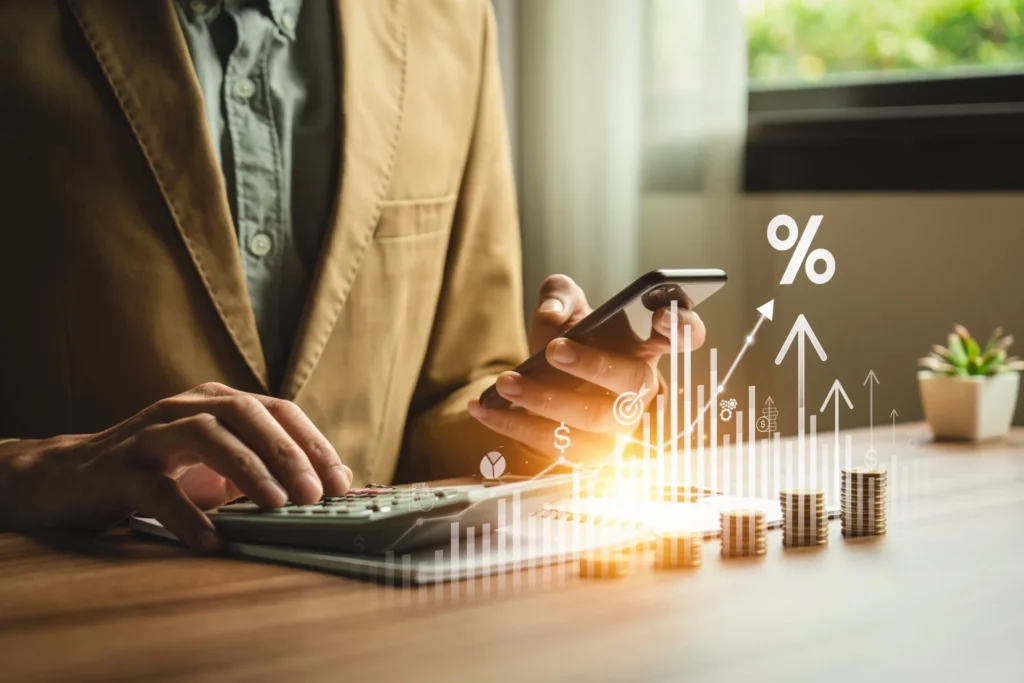 Businessman calculating financial data with a calculator and mobile phone, focusing on passive income for retirement planning