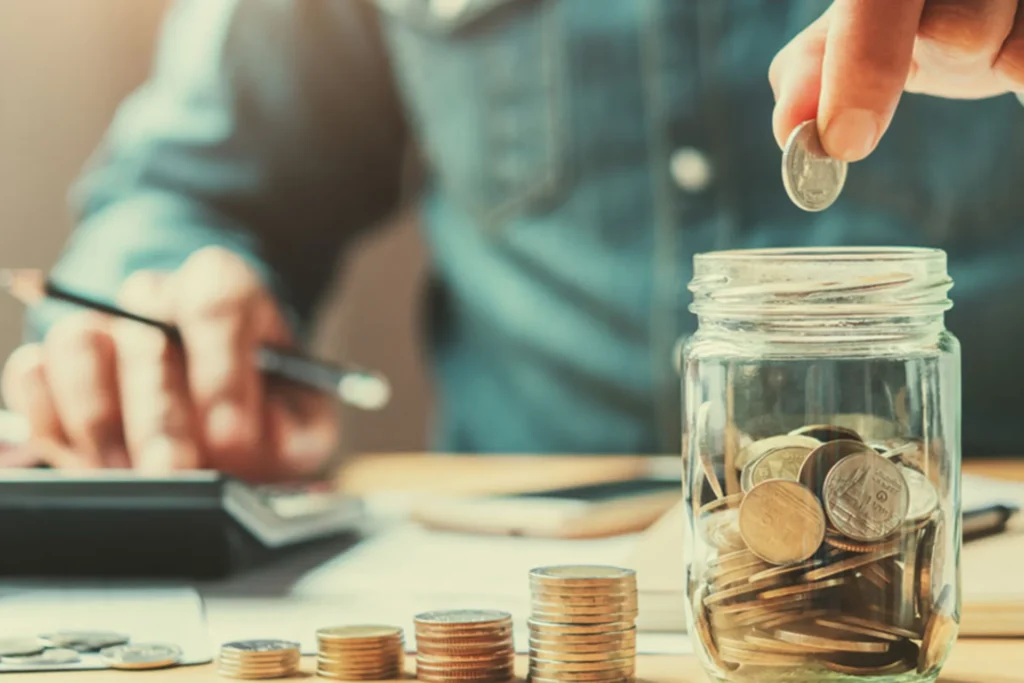 Man placing coins into a jar, symbolizing personalized retirement planning and savings strategies