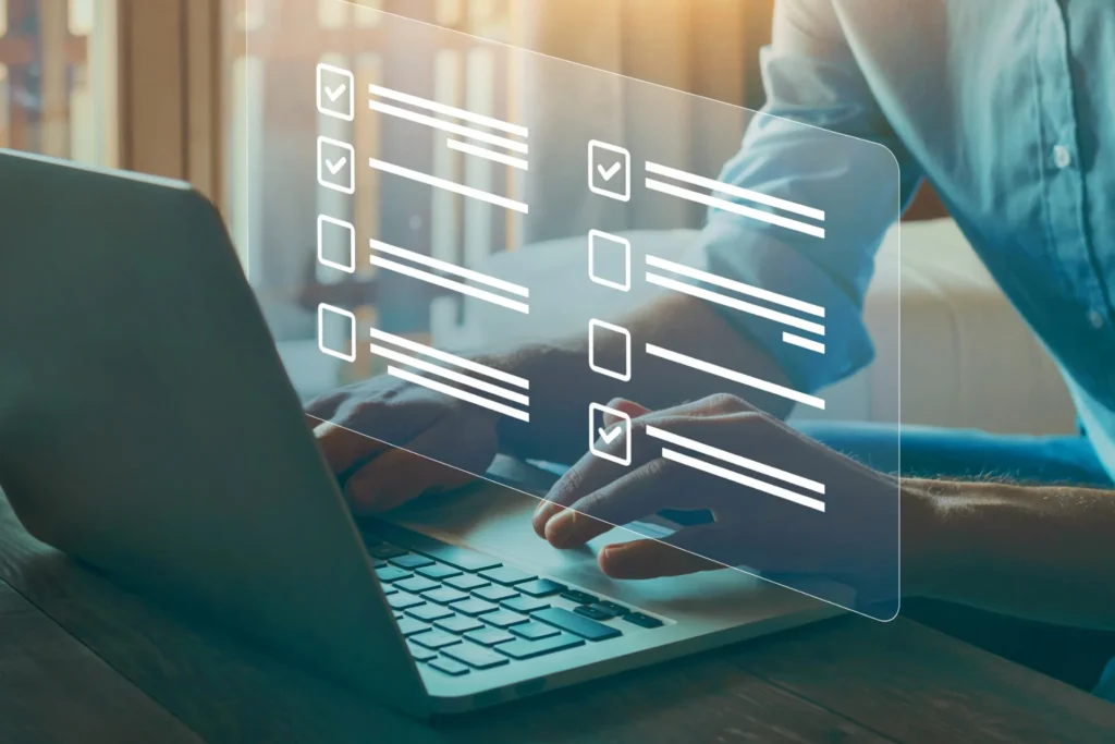 Man working on a laptop with a checklist on the screen, focused on market research and problem identification